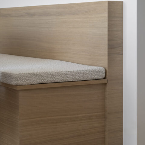 Detail van een ingebouwde zitbank in eik met hoge rugleuning en gestoffeerd zitkussen, maatwerk van YVES Interieur Op Maat.