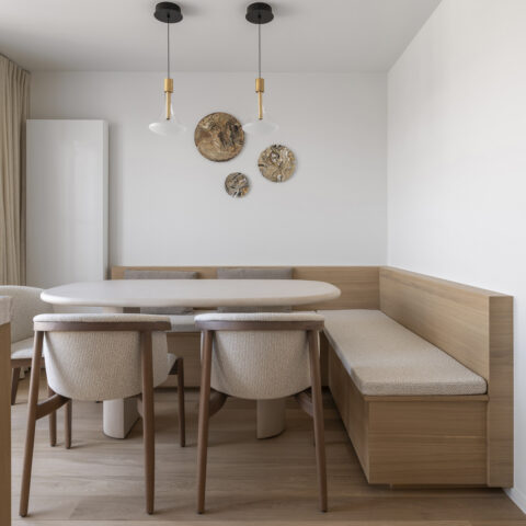 Eethoek met een ingebouwde hoekbank in lichte eik met gestoffeerde zitting rond een ovale tafel, maatwerk van YVES Interieur Op Maat.