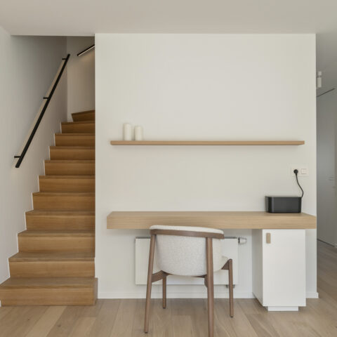 Trap met eiken treden naast een zwevend bureau en wandplank in eik, maatwerk van YVES Interieur Op Maat.
