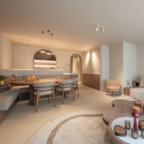 Leefruimte met ingebouwde zitbank in notelaar, eettafel en keuken met verlichte boognis, maatwerk van YVES Interieur Op Maat.